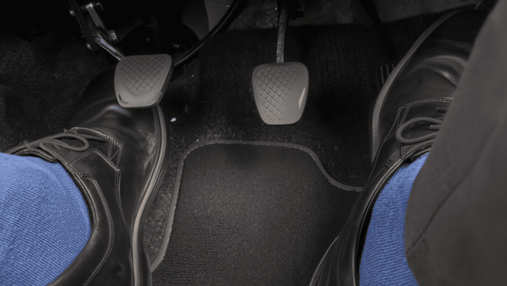 &ldquo;Driver pressing brake pedal showing a soft or spongy brake pedal feel.