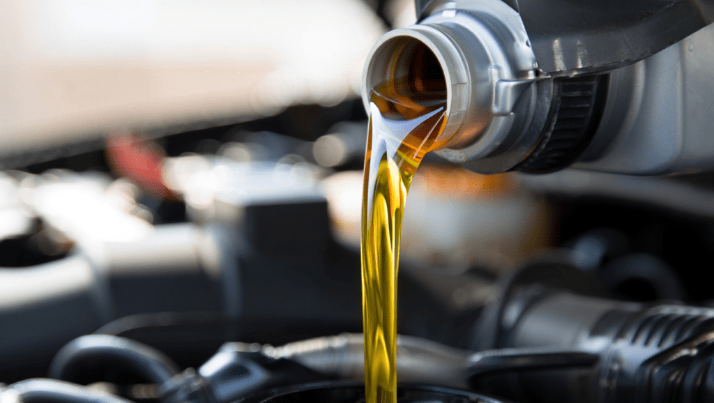 Premium engine oil being poured into a modern car engine at Medway Vehicle Services in Kent
