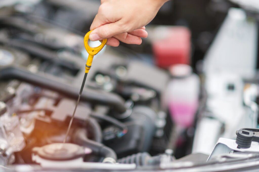 Woman pulling dipstick from car